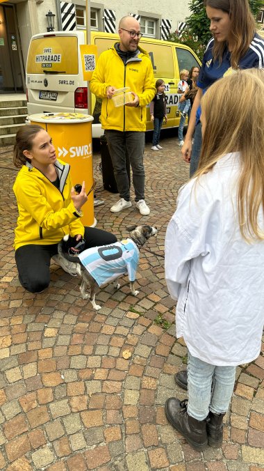 Hund mit Sporttrikot vor SWR1-Moderatorin Mona Böhm