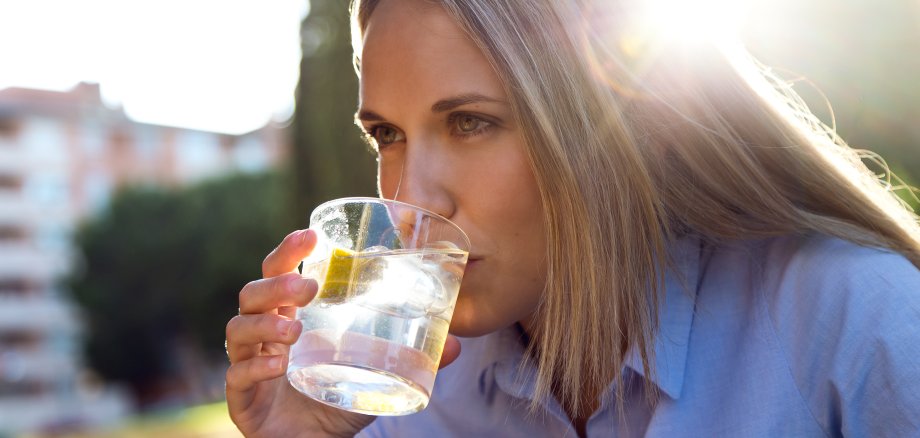 Frau trinkt Wasser aus einem Glas